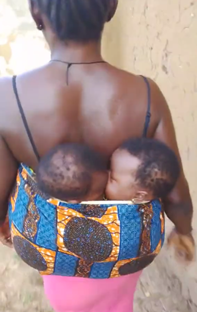 A woman stirs both interest and controversy online while carrying her twins on her back (VIDEO)